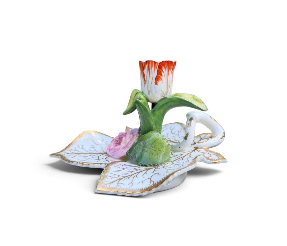 An English porcelain chamberstick designed as a leaf base with a central tulip-shaped candle sconce hand-painted in red, green, pink, and gold.