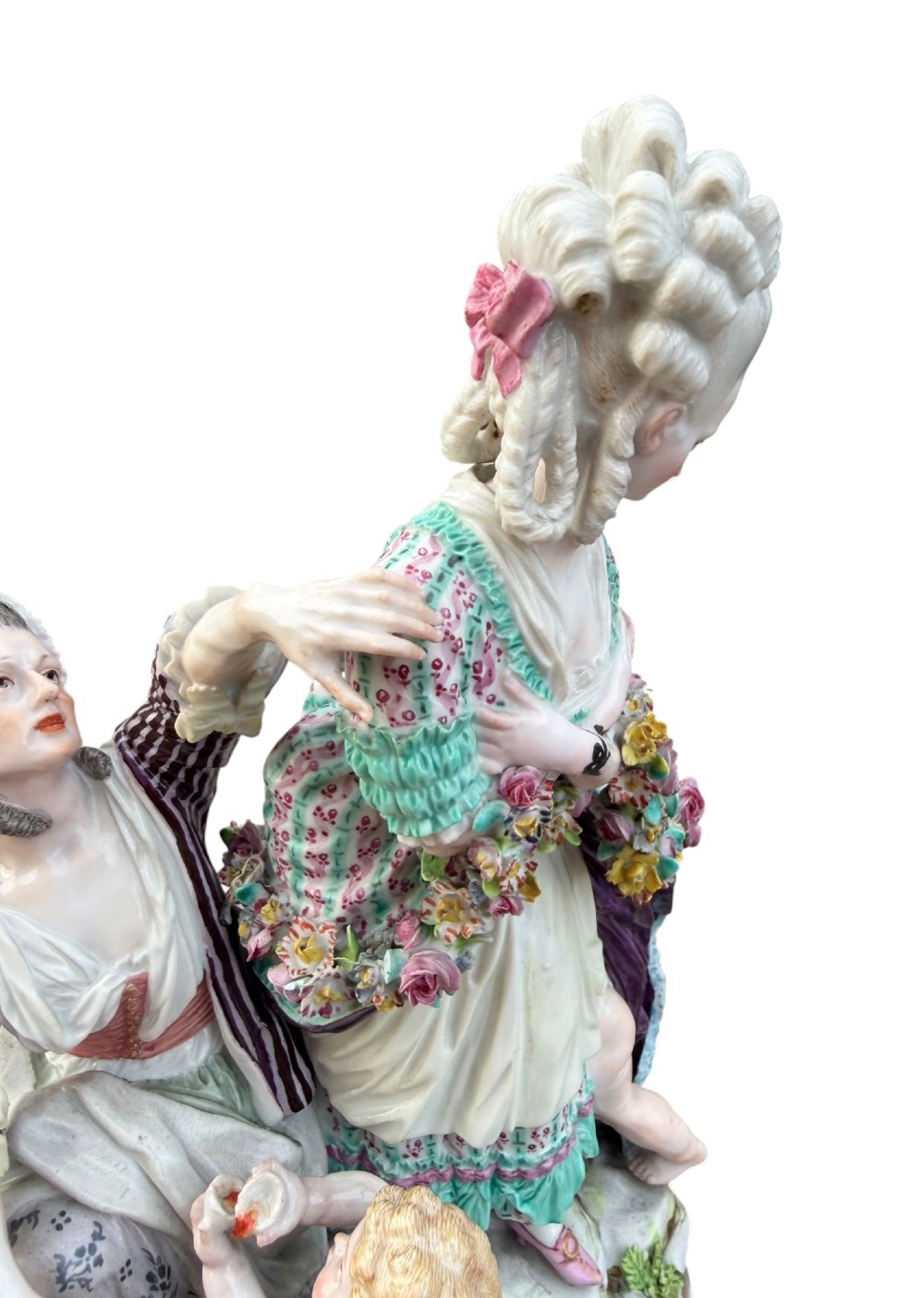 An eighteenth-century polychrome hard-paste porcelain figurine group depicting two classical figures and a cherub beside an overturned basket of eggs on a moulded fluted base. View IX