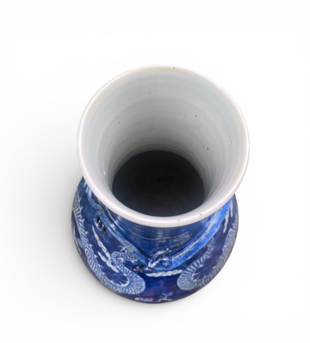 A 19th-century Qing Dynasty Chinese blue and white porcelain vase with hand-painted cloud motifs and an applied sculpted high-relief dragon around the neck. View X