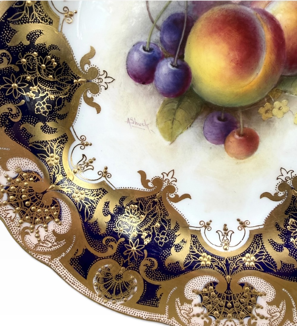 A circular Royal Worcester porcelain cabinet plate featuring a central hand-painted fruit study surrounded by an ornate cobalt blue and gilded rim. View II