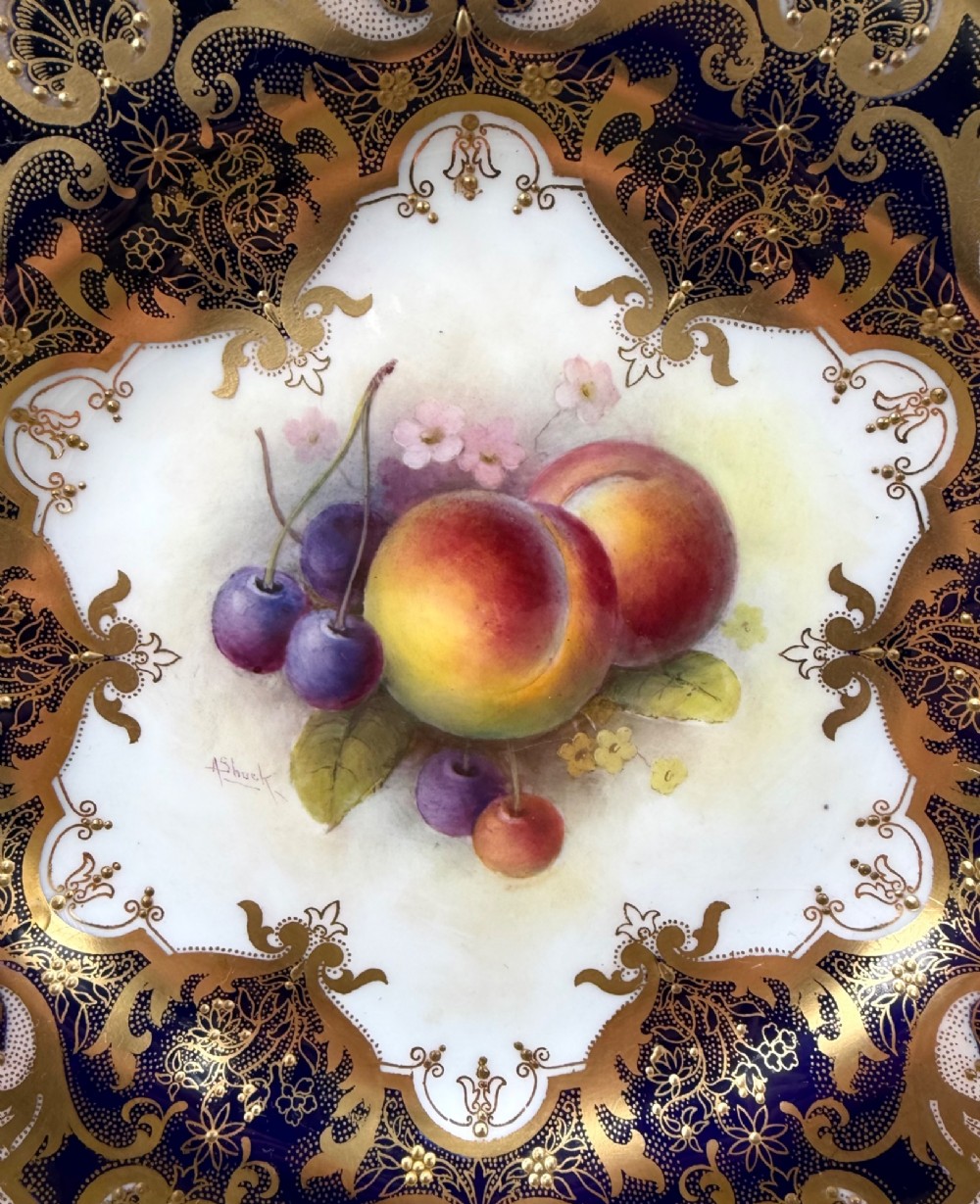 A circular Royal Worcester porcelain cabinet plate featuring a central hand-painted fruit study surrounded by an ornate cobalt blue and gilded rim. View V