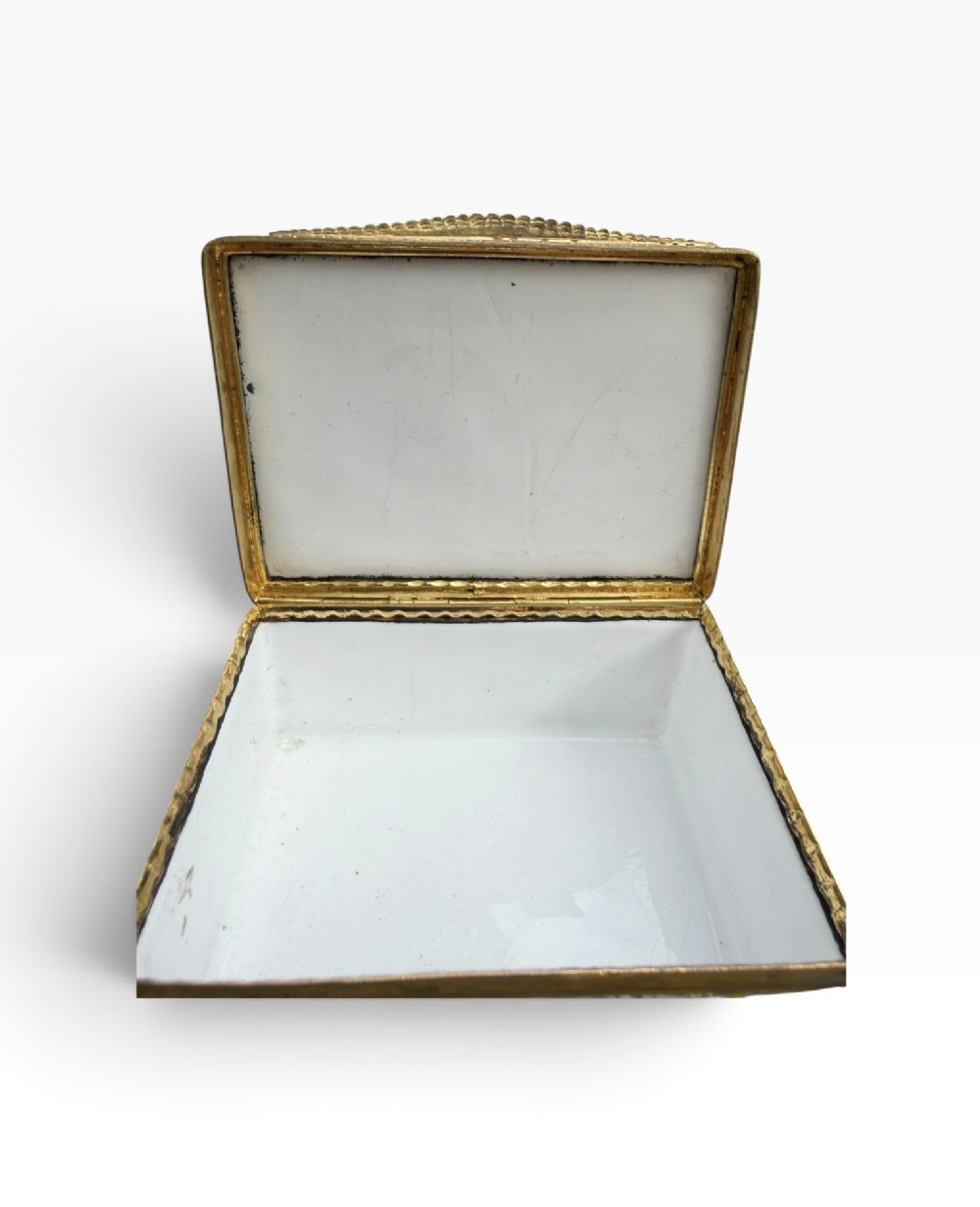 A rectangular Georgian enamel snuff box featuring a light blue trellis background, gilt metal mounts, and hand-painted pastoral scenes in central cartouches. View VIII