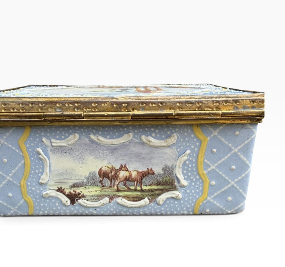A rectangular Georgian enamel snuff box featuring a light blue trellis background, gilt metal mounts, and hand-painted pastoral scenes in central cartouches. View XIII