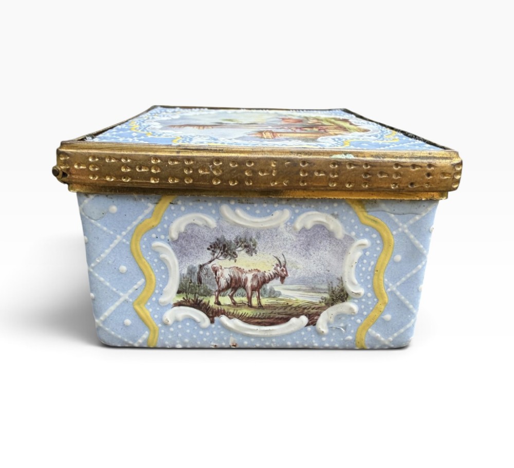 A rectangular Georgian enamel snuff box featuring a light blue trellis background, gilt metal mounts, and hand-painted pastoral scenes in central cartouches. View XIV