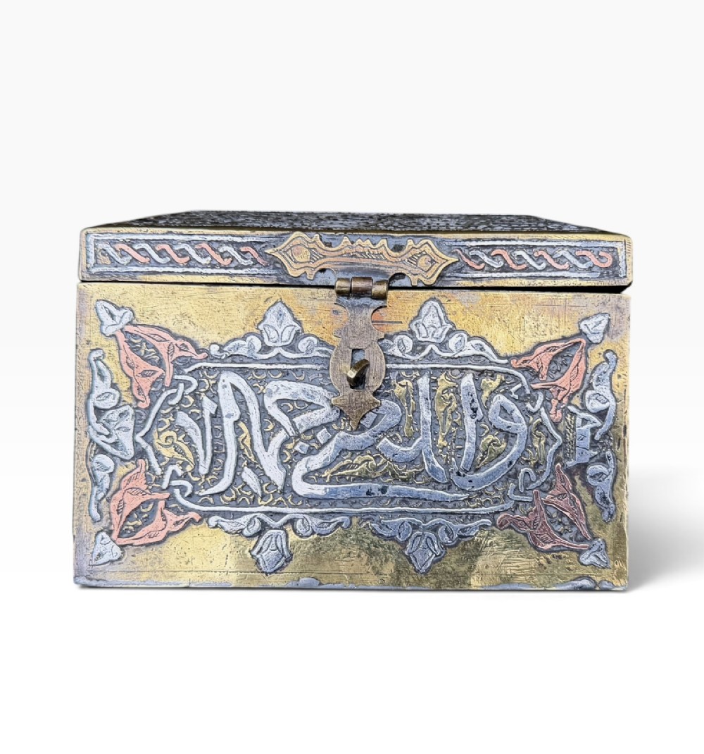 A square brass Quran casket featuring intricate silver and copper inlaid Arabic calligraphy and geometric interlace patterns. View VI