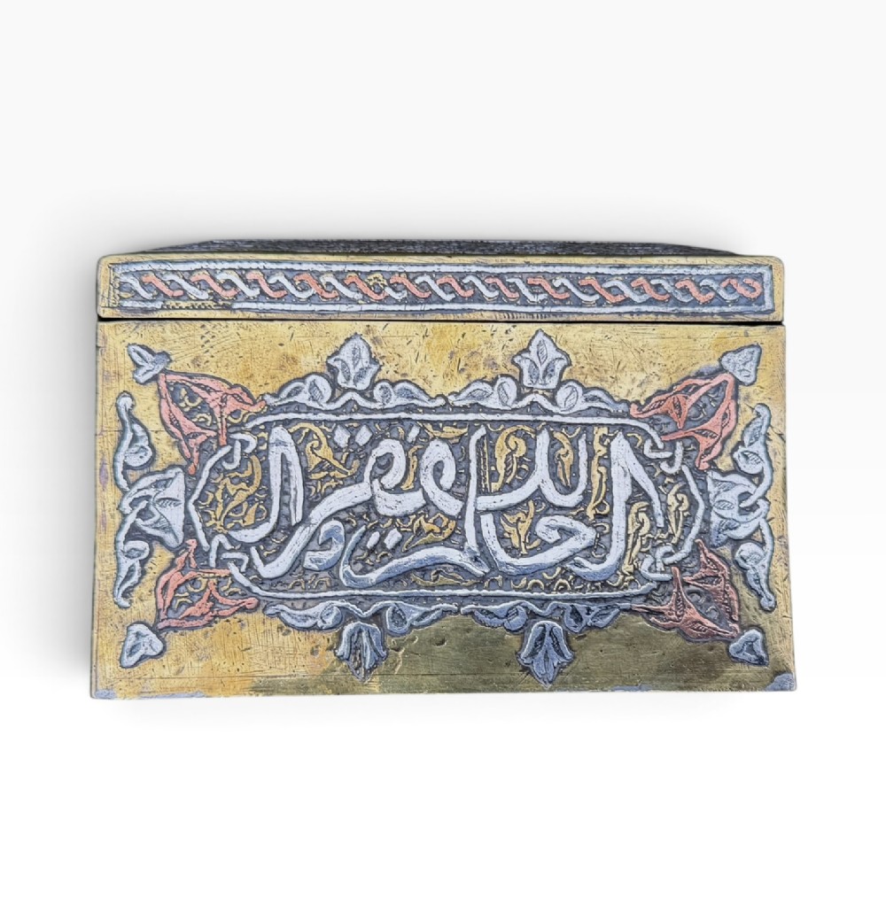 A square brass Quran casket featuring intricate silver and copper inlaid Arabic calligraphy and geometric interlace patterns. View VII