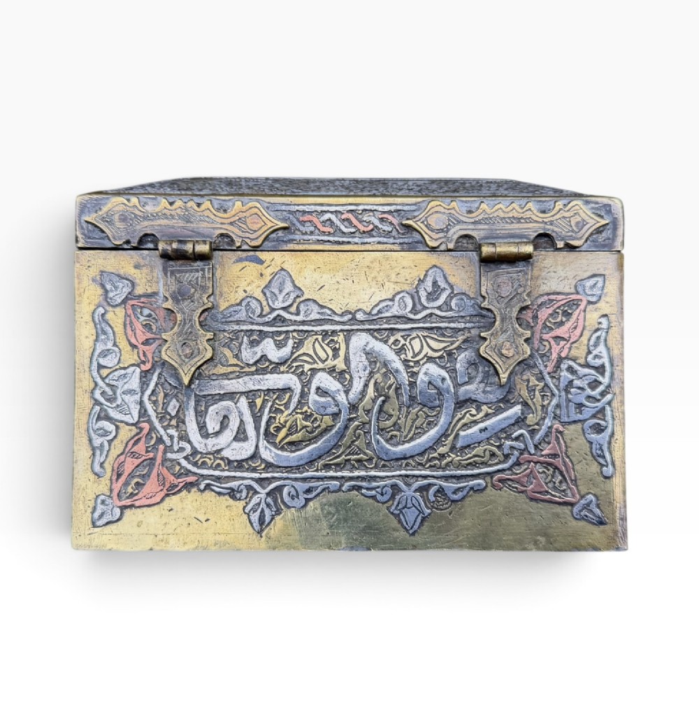 A square brass Quran casket featuring intricate silver and copper inlaid Arabic calligraphy and geometric interlace patterns. View VIII