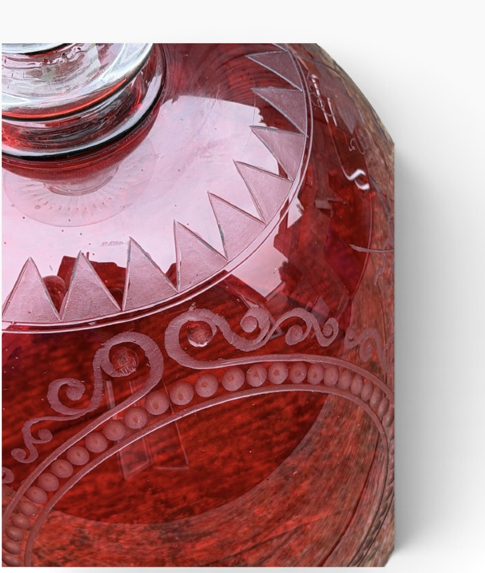 A Victorian cranberry glass goblet with intricately wheel-engraved Masonic symbols on a red bowl, supported by a clear knopped glass stem and a star-cut circular base. View XV
