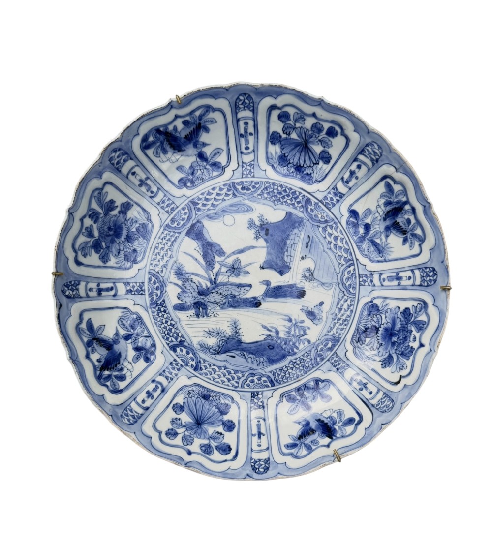 An antique Chinese Kraak porcelain dish featuring underglaze cobalt blue decoration, a central roundel with waterfowl, and a lobed border with radiating panels.