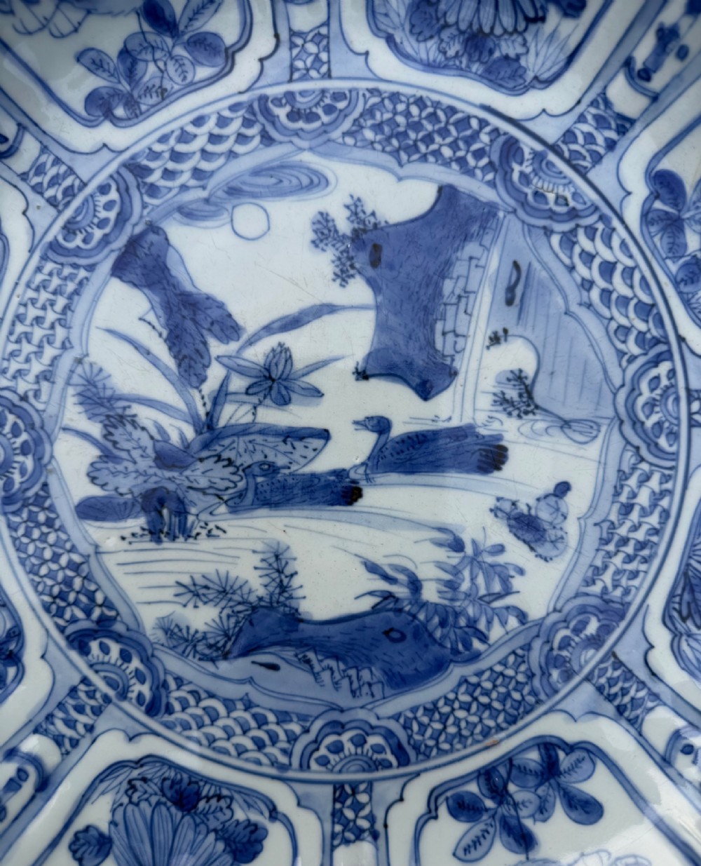 An antique Chinese Kraak porcelain dish featuring underglaze cobalt blue decoration, a central roundel with waterfowl, and a lobed border with radiating panels. View II