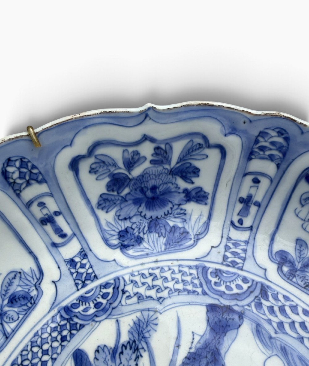 An antique Chinese Kraak porcelain dish featuring underglaze cobalt blue decoration, a central roundel with waterfowl, and a lobed border with radiating panels. View VI