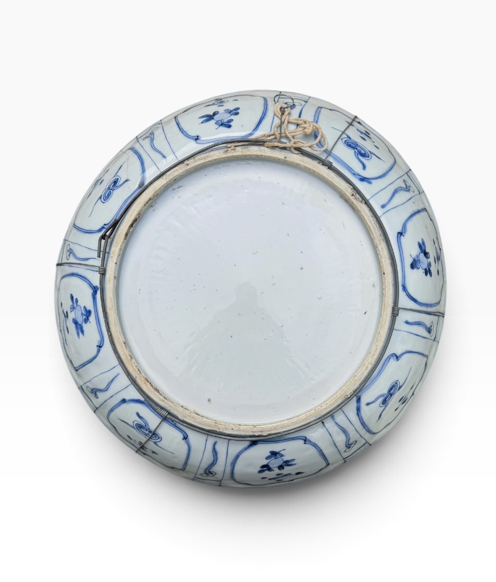 An antique Chinese Kraak porcelain dish featuring underglaze cobalt blue decoration, a central roundel with waterfowl, and a lobed border with radiating panels. View VII