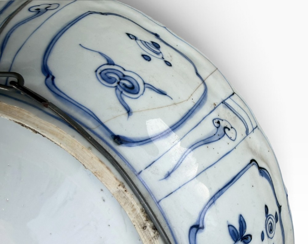 An antique Chinese Kraak porcelain dish featuring underglaze cobalt blue decoration, a central roundel with waterfowl, and a lobed border with radiating panels. View IX