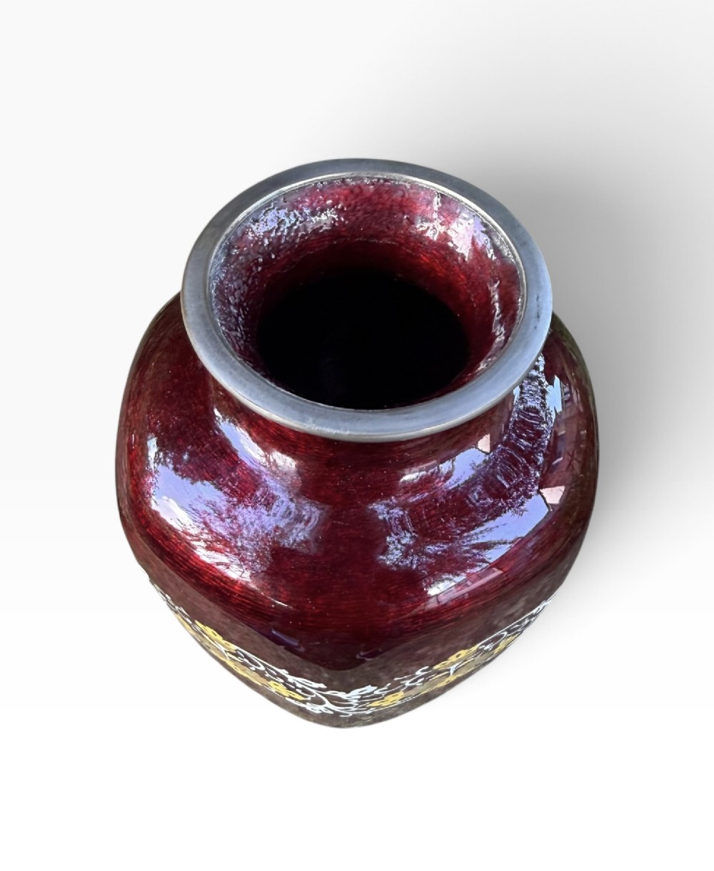 A baluster-shaped Japanese ginbari cloisonne vase featuring deep crimson enamel over foil, decorated with a band of yellow blossoms and white scrolling foliage around the center. View VI