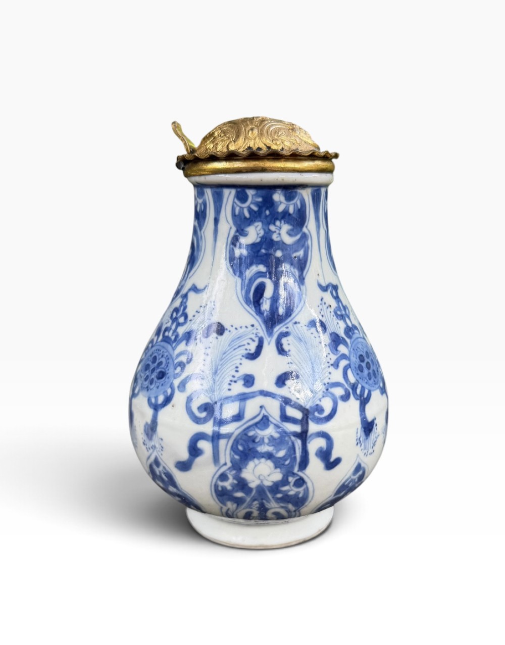 A blue and white Kangxi period Chinese porcelain jug with hand-painted floral decoration, an angular ceramic handle, and a chased gilt-metal lid. View III