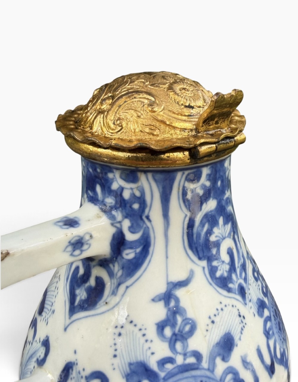 A blue and white Kangxi period Chinese porcelain jug with hand-painted floral decoration, an angular ceramic handle, and a chased gilt-metal lid. View VIII