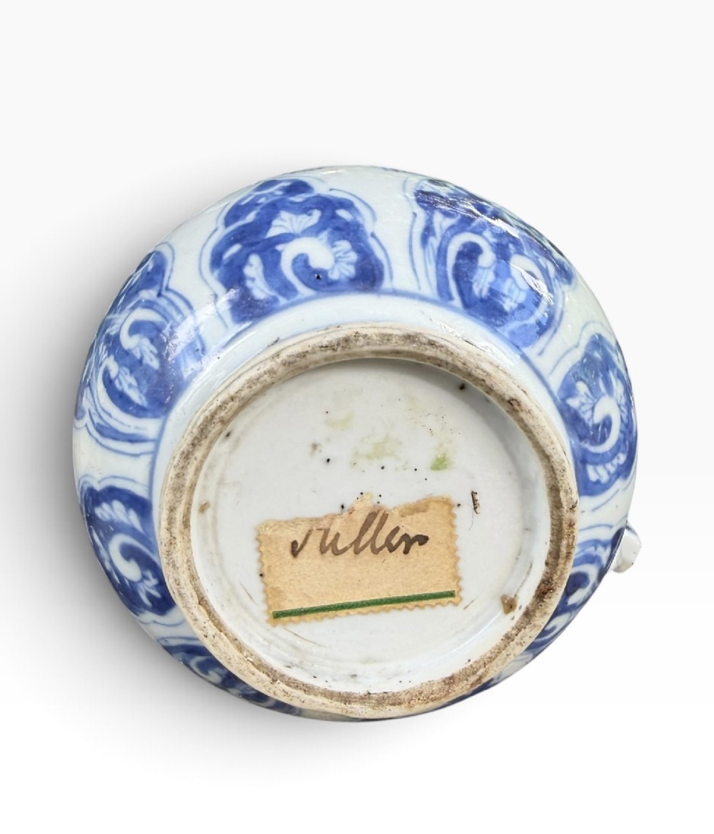 A blue and white Kangxi period Chinese porcelain jug with hand-painted floral decoration, an angular ceramic handle, and a chased gilt-metal lid. View XI