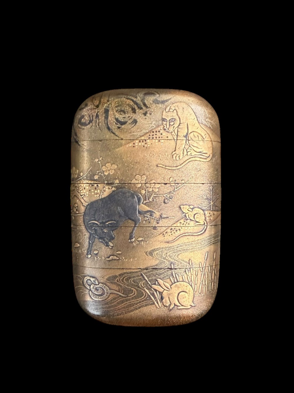 A multi-tiered Japanese gold maki-e lacquer inro featuring detailed relief depictions of zodiac animals including an ox, rabbit, rat, snake, and tiger.