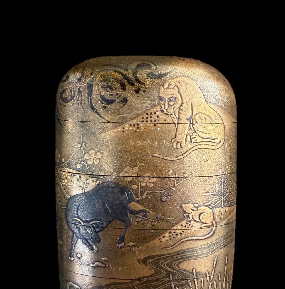 A multi-tiered Japanese gold maki-e lacquer inro featuring detailed relief depictions of zodiac animals including an ox, rabbit, rat, snake, and tiger. View III