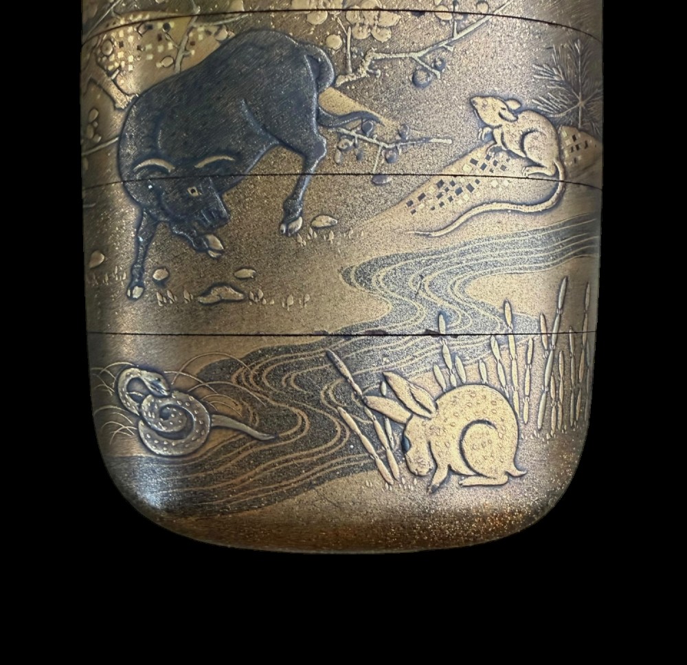 A multi-tiered Japanese gold maki-e lacquer inro featuring detailed relief depictions of zodiac animals including an ox, rabbit, rat, snake, and tiger. View V