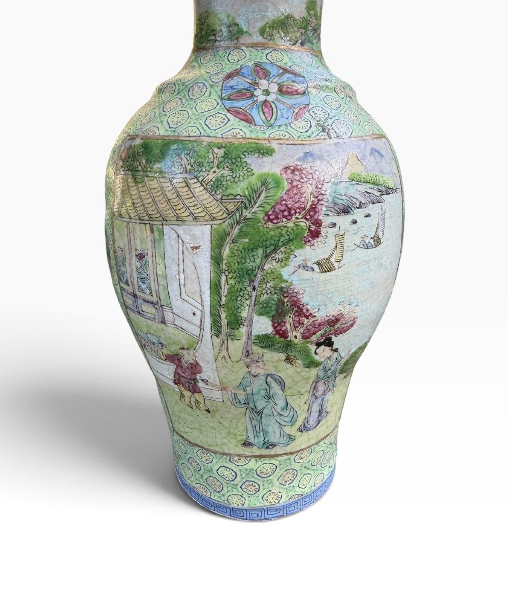 A pair of 19th-century Chinese Yixing stoneware baluster vases decorated in vibrant polychrome enamels with figural panels on a patterned green ground. View IV