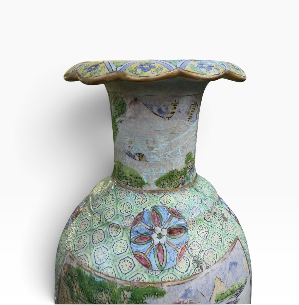 A pair of 19th-century Chinese Yixing stoneware baluster vases decorated in vibrant polychrome enamels with figural panels on a patterned green ground. View V