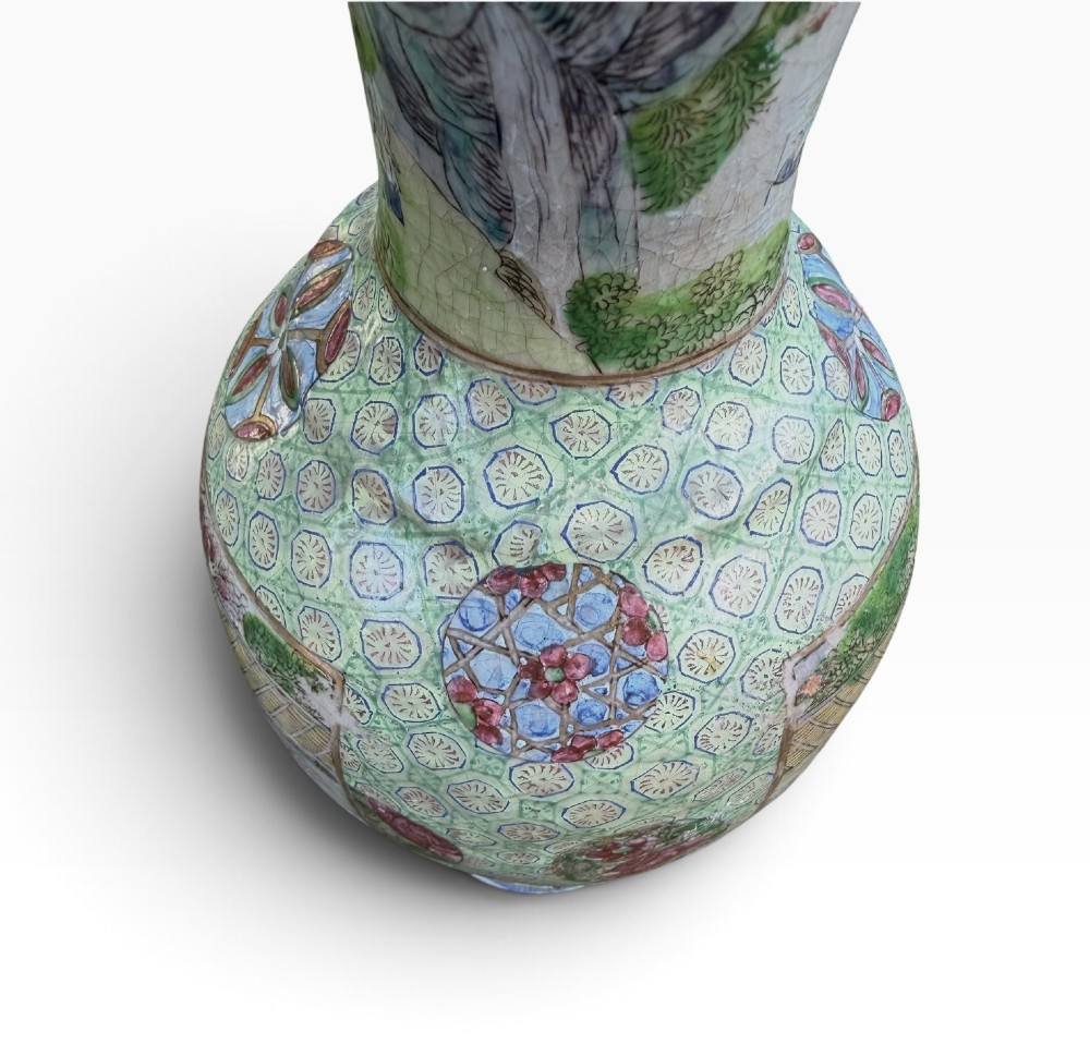 A pair of 19th-century Chinese Yixing stoneware baluster vases decorated in vibrant polychrome enamels with figural panels on a patterned green ground. View X