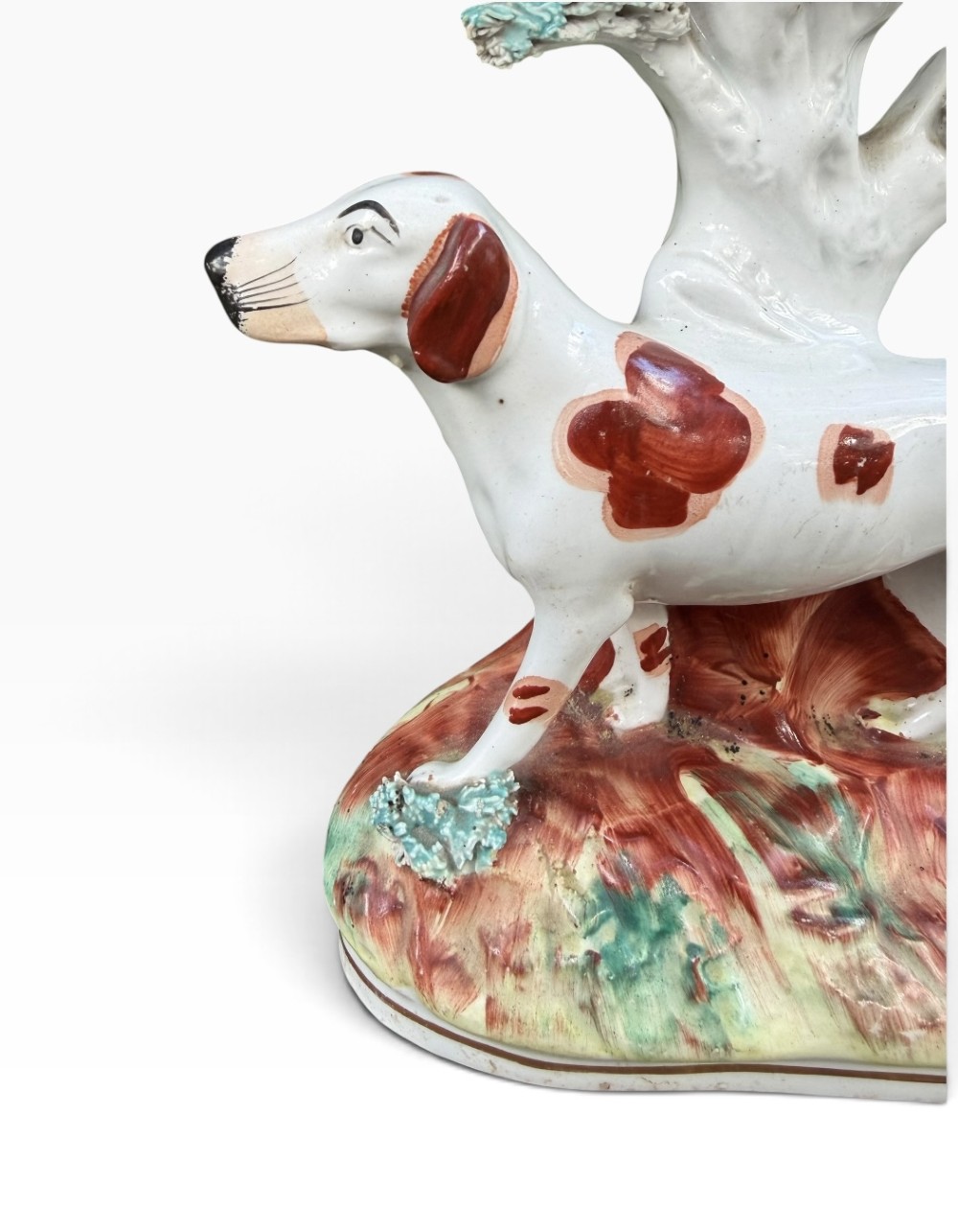 A Victorian Staffordshire pottery spill vase featuring a white and brown pointer dog standing in front of a tree trunk on a moulded base. View V