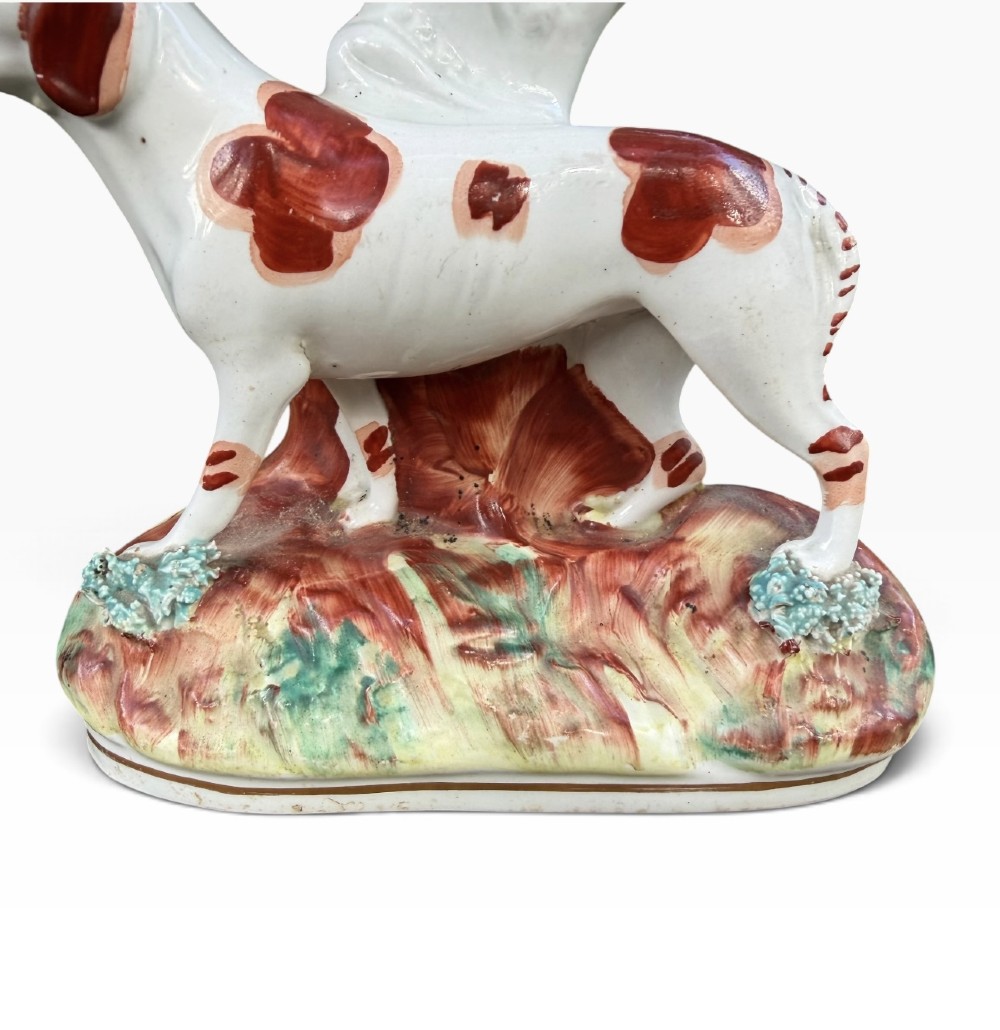 A Victorian Staffordshire pottery spill vase featuring a white and brown pointer dog standing in front of a tree trunk on a moulded base. View VI