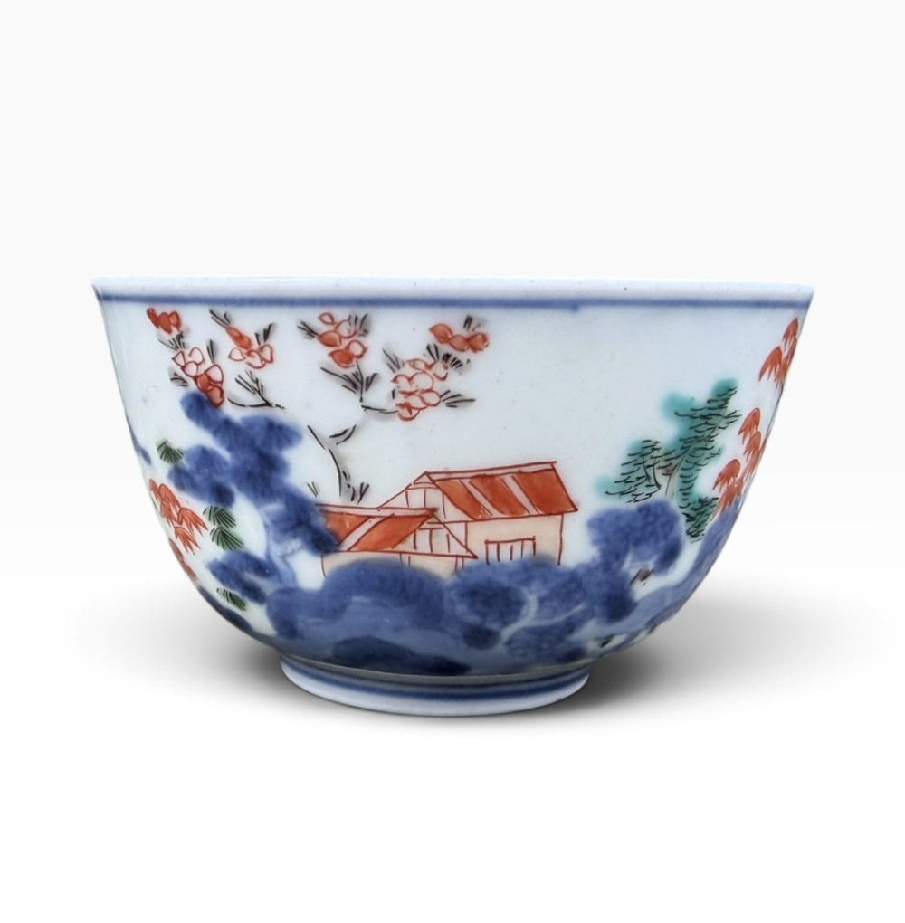 A small Japanese porcelain teabowl decorated with hand-painted figures, foliage, and landscapes in blue, red, green, and yellow enamels. View IV