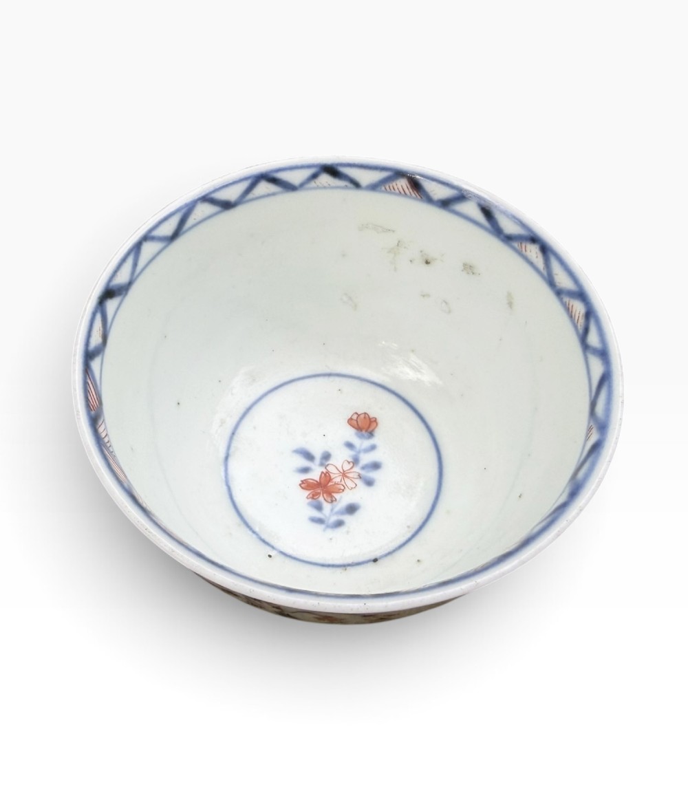 A small Japanese porcelain teabowl decorated with hand-painted figures, foliage, and landscapes in blue, red, green, and yellow enamels. View VI