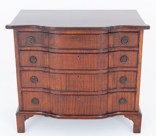 fig 1. A Georgian Revival mahogany chest of drawers featuring four shaped drawers with circular brass ring handles and bracket feet.