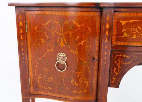 fig 1. A Sheraton Revival mahogany sideboard featuring intricate floral marquetry inlay, a central drawer, flanking cupboard doors, and square tapered legs.