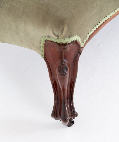 fig 1. A Victorian rosewood chaise longue featuring deep-buttoned sage green velvet upholstery, an asymmetrical scrolled backrest, and carved cabriole legs with castors.