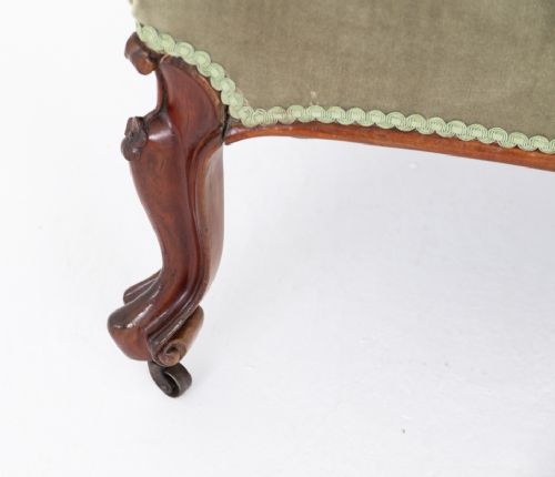 fig 2. A Victorian rosewood chaise longue featuring deep-buttoned sage green velvet upholstery, an asymmetrical scrolled backrest, and carved cabriole legs with castors.