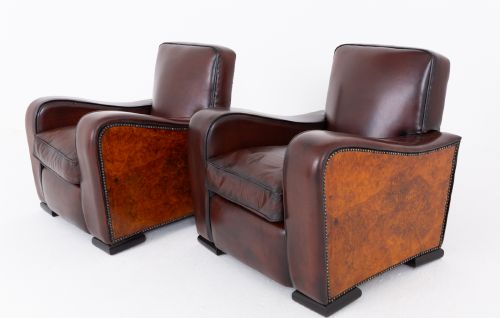 fig 2. A pair of Art Deco club chairs upholstered in brown leather with burr walnut side panels and studded trim.