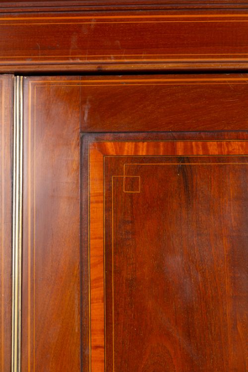 A tall Sheraton Revival mahogany two-door wardrobe featuring inlaid panelled doors, a lower base drawer, and bracket feet. View IV