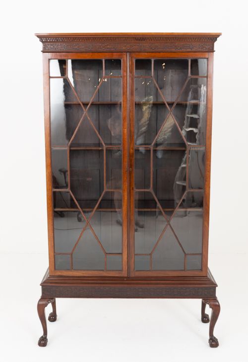 A mahogany Chippendale style glazed bookcase featuring geometric glass door panels, a carved frieze, and cabriole legs ending in ball and claw feet. View III