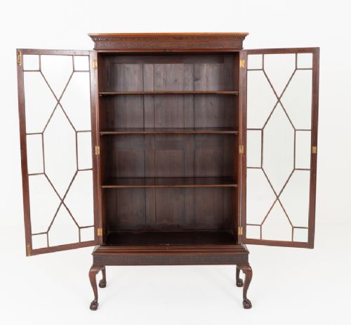 A mahogany Chippendale style glazed bookcase featuring geometric glass door panels, a carved frieze, and cabriole legs ending in ball and claw feet. View VI