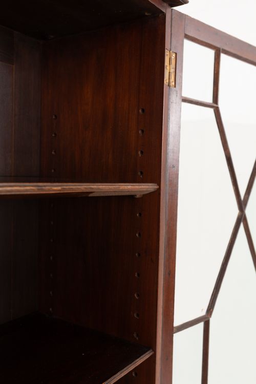 A mahogany Chippendale style glazed bookcase featuring geometric glass door panels, a carved frieze, and cabriole legs ending in ball and claw feet. View VII
