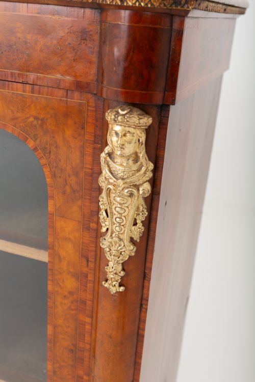 fig 2. A Victorian burr walnut credenza featuring three arched glazed doors, intricate gilt ormolu mounts, and a solid plinth base.
