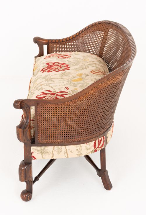 A three-piece Carolean style seating suite comprising a settee and two matching armchairs with woven cane backrests, carved scroll stretchers, and floral fabric seat cushions. View VIII