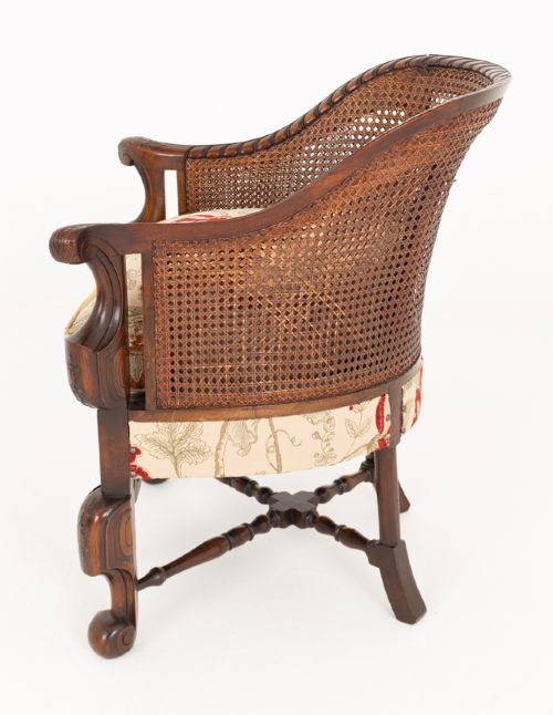 A three-piece Carolean style seating suite comprising a settee and two matching armchairs with woven cane backrests, carved scroll stretchers, and floral fabric seat cushions. View XIII