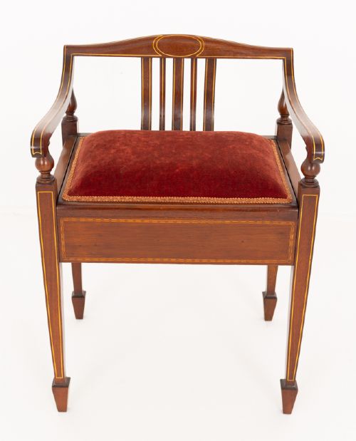 fig 1. A Sheraton Revival mahogany piano stool featuring a slatted curved backrest, curved arms, red velvet cushioned seat, and square tapered legs with inlaid boxwood stringing.