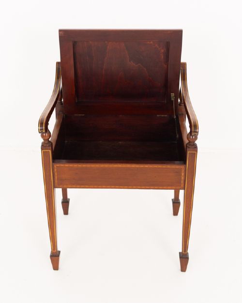 A Sheraton Revival mahogany piano stool featuring a slatted curved backrest, curved arms, red velvet cushioned seat, and square tapered legs with inlaid boxwood stringing. View V
