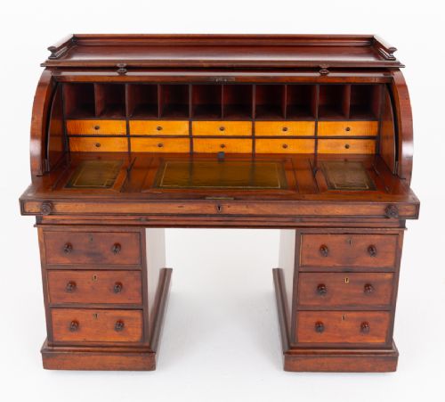 A Victorian mahogany cylinder desk featuring a curved roll-top hood, multiple pedestal drawers, and turned wooden knobs. View IV