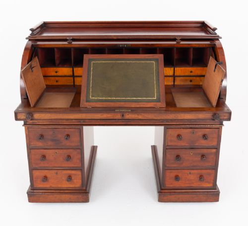 A Victorian mahogany cylinder desk featuring a curved roll-top hood, multiple pedestal drawers, and turned wooden knobs. View V