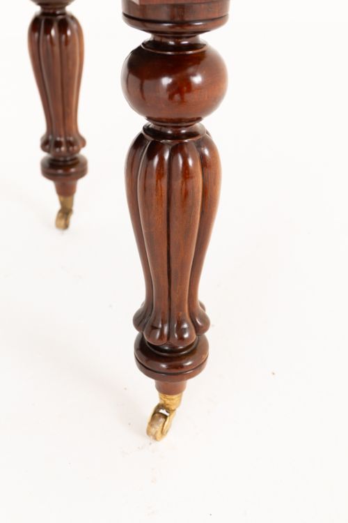 A William IV mahogany extending dining table supported by four reeded turned legs with brass castors. View III