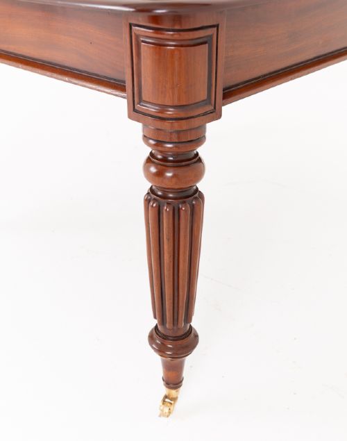 fig 1. A Regency mahogany extending dining table with two removable leaves, turned reeded legs, and brass castors.