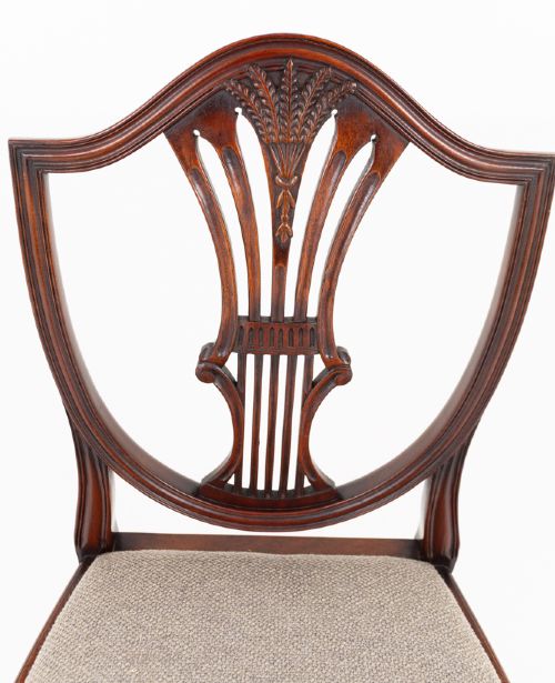 A set of eight mahogany shield back dining chairs comprising six side chairs and two carvers with neutral beige fabric seats. View VIII